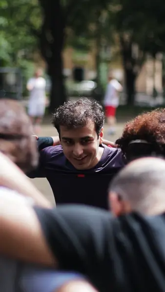 Smiling player with curly hair in a team huddle outdoors